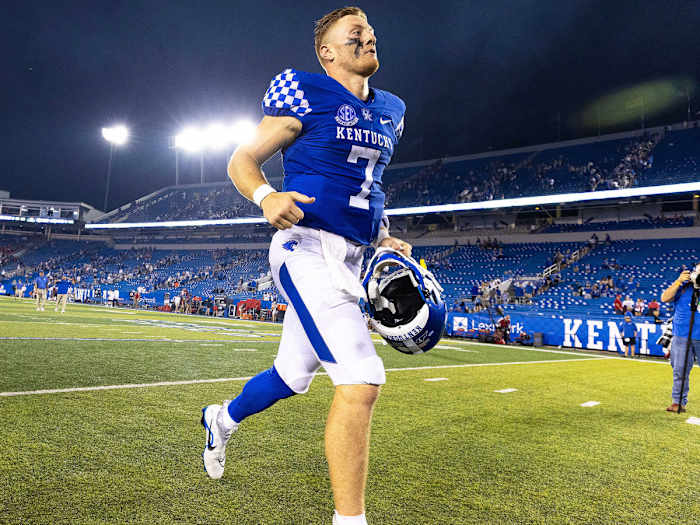 Will Levis runs on the field while holding a helmet